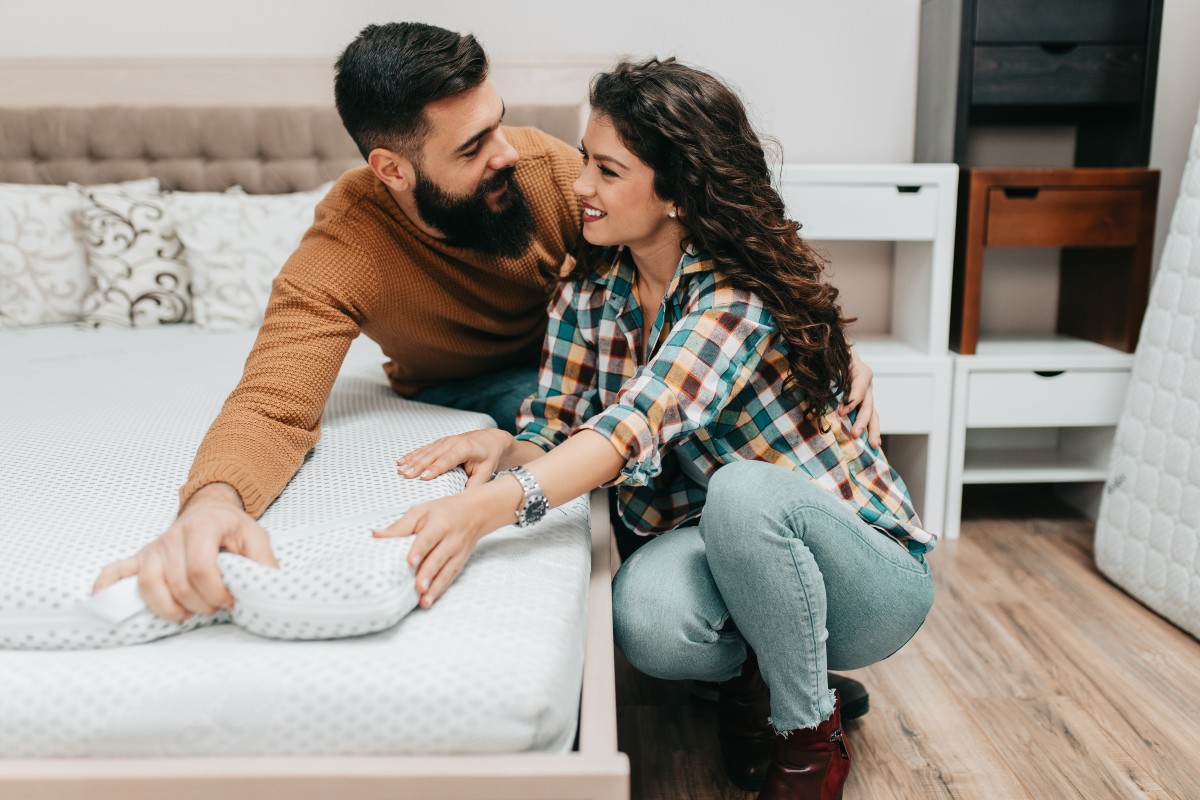 A happy couple shopping together for a new mattress